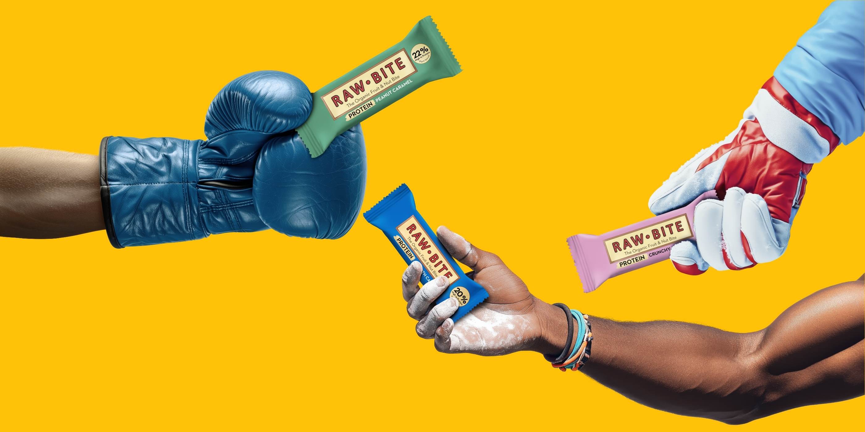 RAWBITE proteinbarer i hver sin sporty hånd på gul baggrund